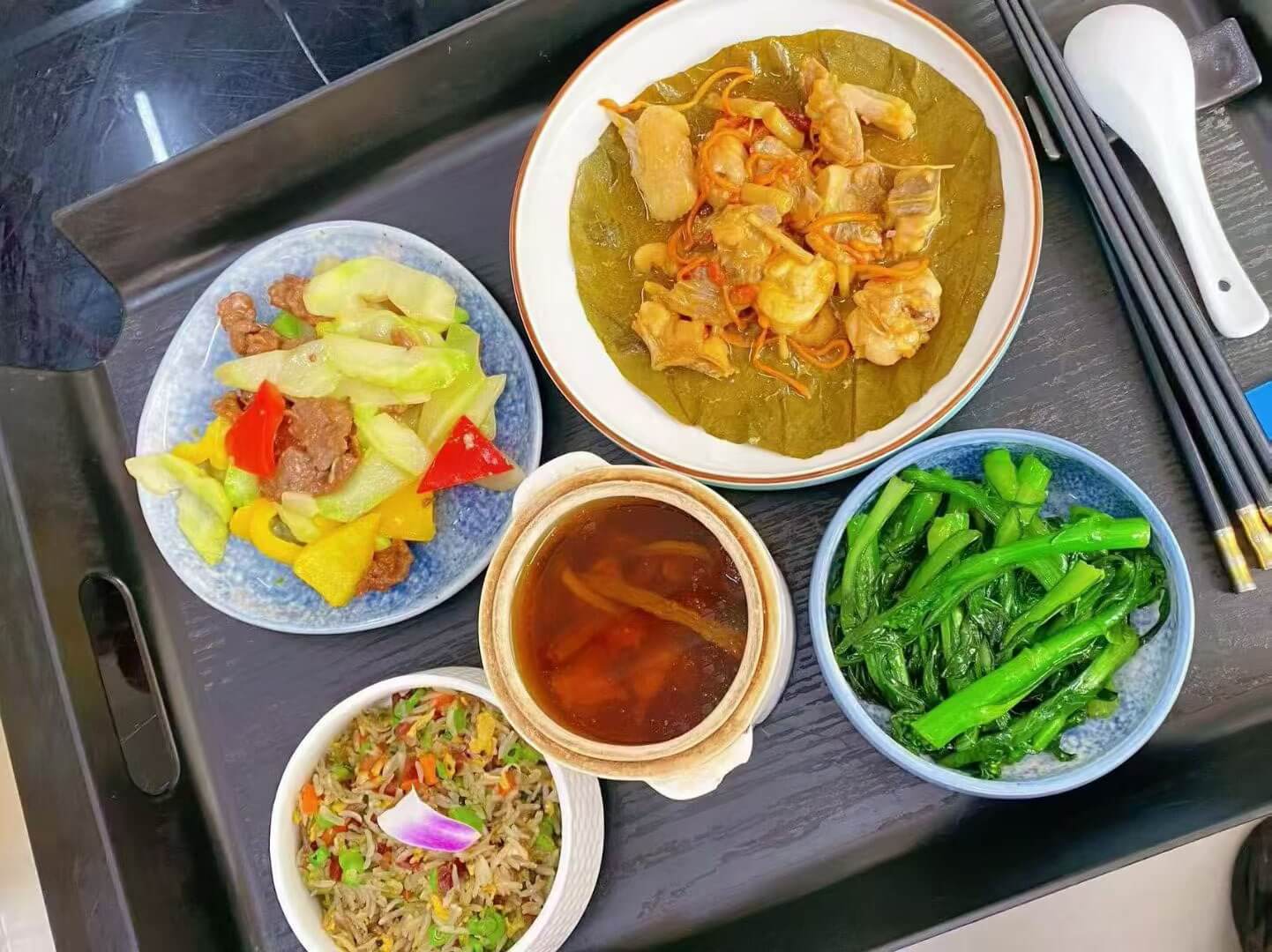 迎月湾独立厨房出品的营养月子餐，含杂菜炒饭、汤品、蒸鸡和时蔬
